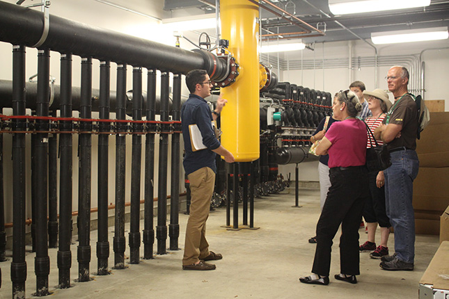 Levi Rogers gives campus visitors a tour of Skidmore geothermal system