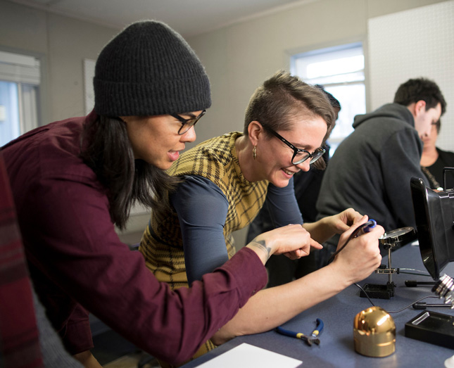 Ho’o Hee, left with the Skidmore College Makerspace assists Sarah Friedland, Storytellers' Institute Director with soldering during an open house at The Hub