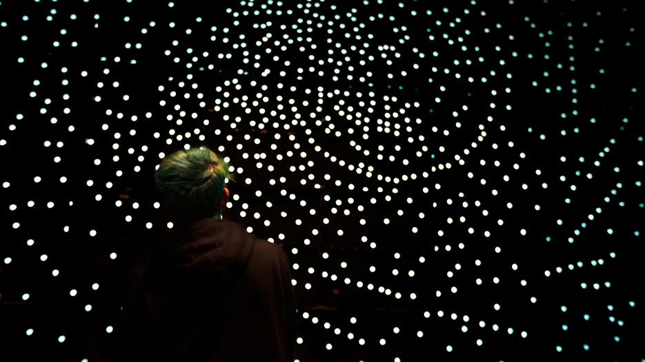 a student watches sunlight stream through a back-stage screen at the Saratoga Performing Arts Center 