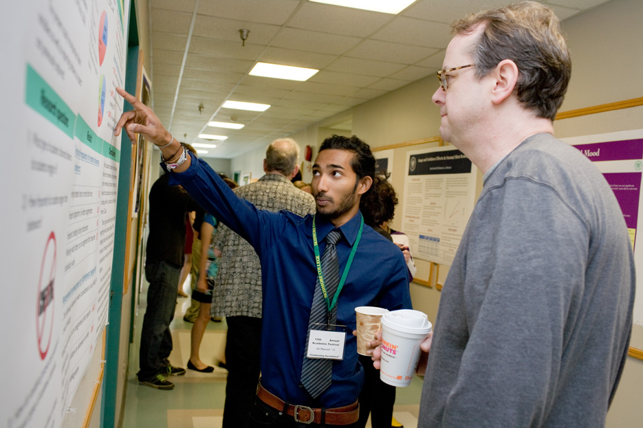 Student points to a research poster during Academic Fest
