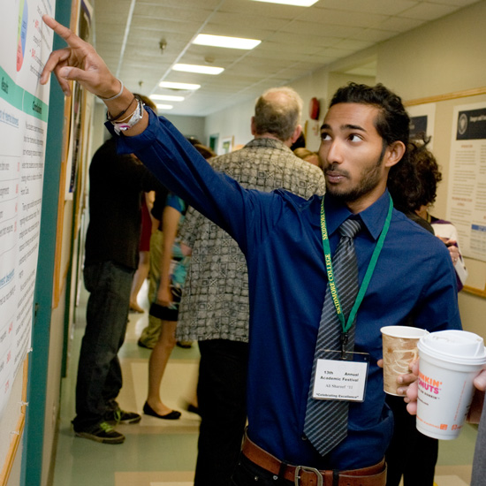 Student+points+to+a+research+poster+during+Academic+Fest