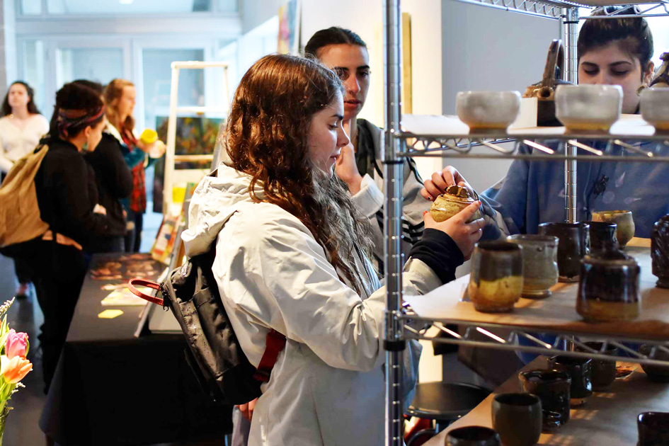 A student holds handmade pottery at the Handmade Pop-Up store on April 27