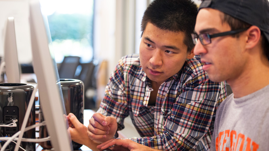 Two male students work on a computer together at Skidmore College