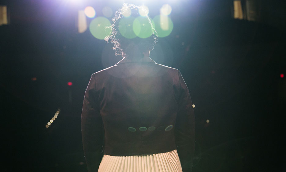 young woman standing at a microphone on stage