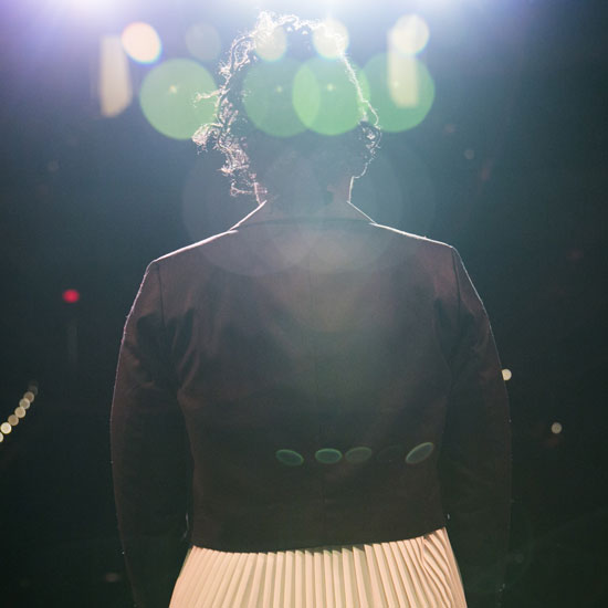 young+woman+standing+at+a+microphone+on+stage
