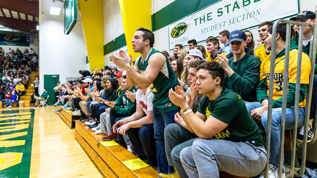 A crowd of student clap and cheer for Skidmore's basketball team from the stands