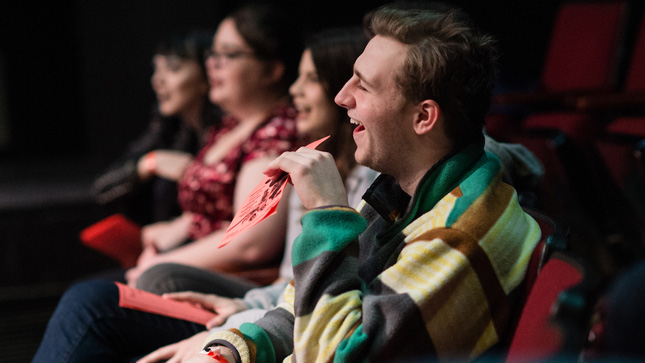 Crowd of students laughing at a comedy sketch performance