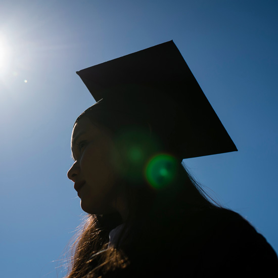 A+silhouette+of+a+college+graduate+in+her+cap+and+gown+