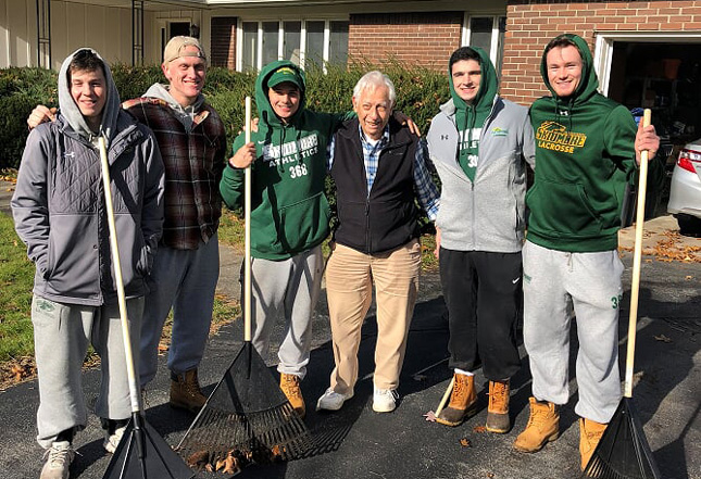 Skidmore students volunteering to rake people's yards