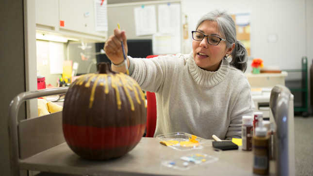 Woman painting a pumpkin