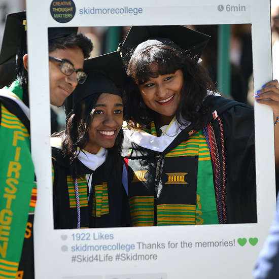Students+pose+for+a+photo+in+their+commencement+regalia+