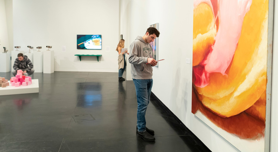 Students taking notes at an art exhibit 