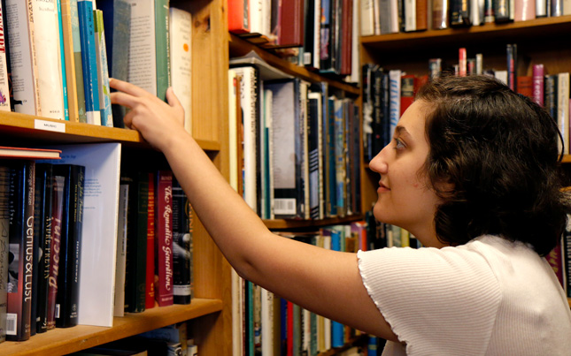 A college student browses in a local bookstore