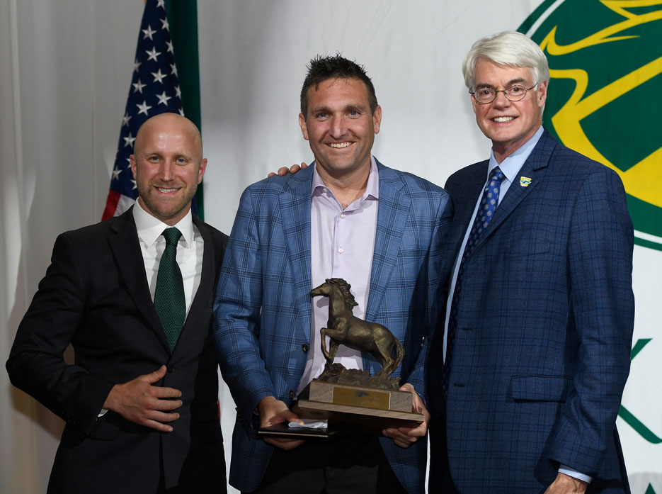 From left, men's hockey coach, Robert Hutchison, ,Peter Conlin '98 and President Philip A. Glotzbach 