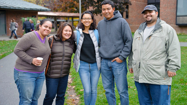 Skidmore student poses with their family on campus