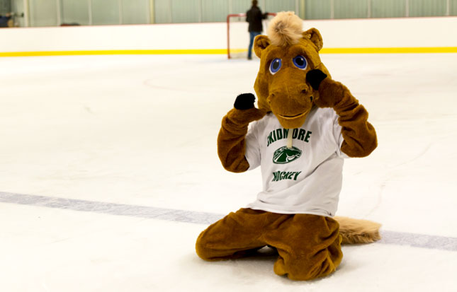 Skidmore mascot poses on the ice rink during a hockey game