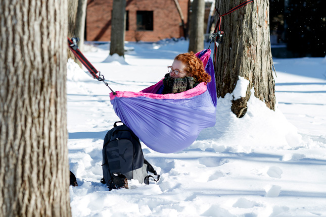 Student sits in a hammock outside in the winter
