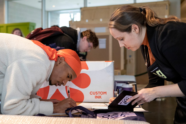Malchijah Hoskins '22 signs his loan agreement for Romare Bearden’s "Three Women (Easter Sunday)" with Tang staff member Annelise Kelly.(Photo: Dan Lubbers)
