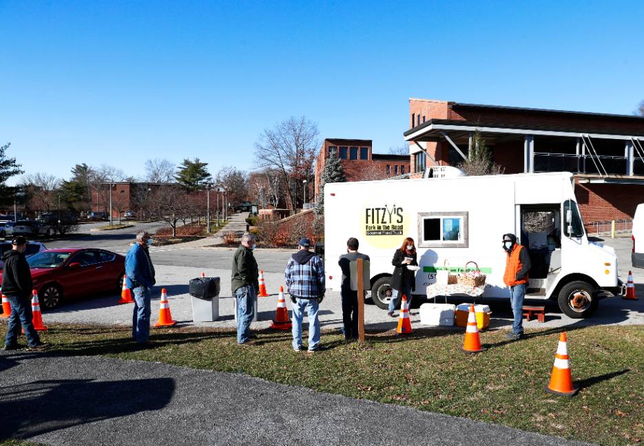 Employees line up for a meal from a food truck on campus.