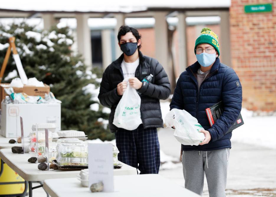 Students pick up meals outside the Murray-Aikin Dining Hall during "safe-shelter" mode