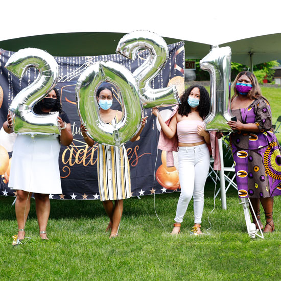 Four+students+hold+balloons+that+say+2021+