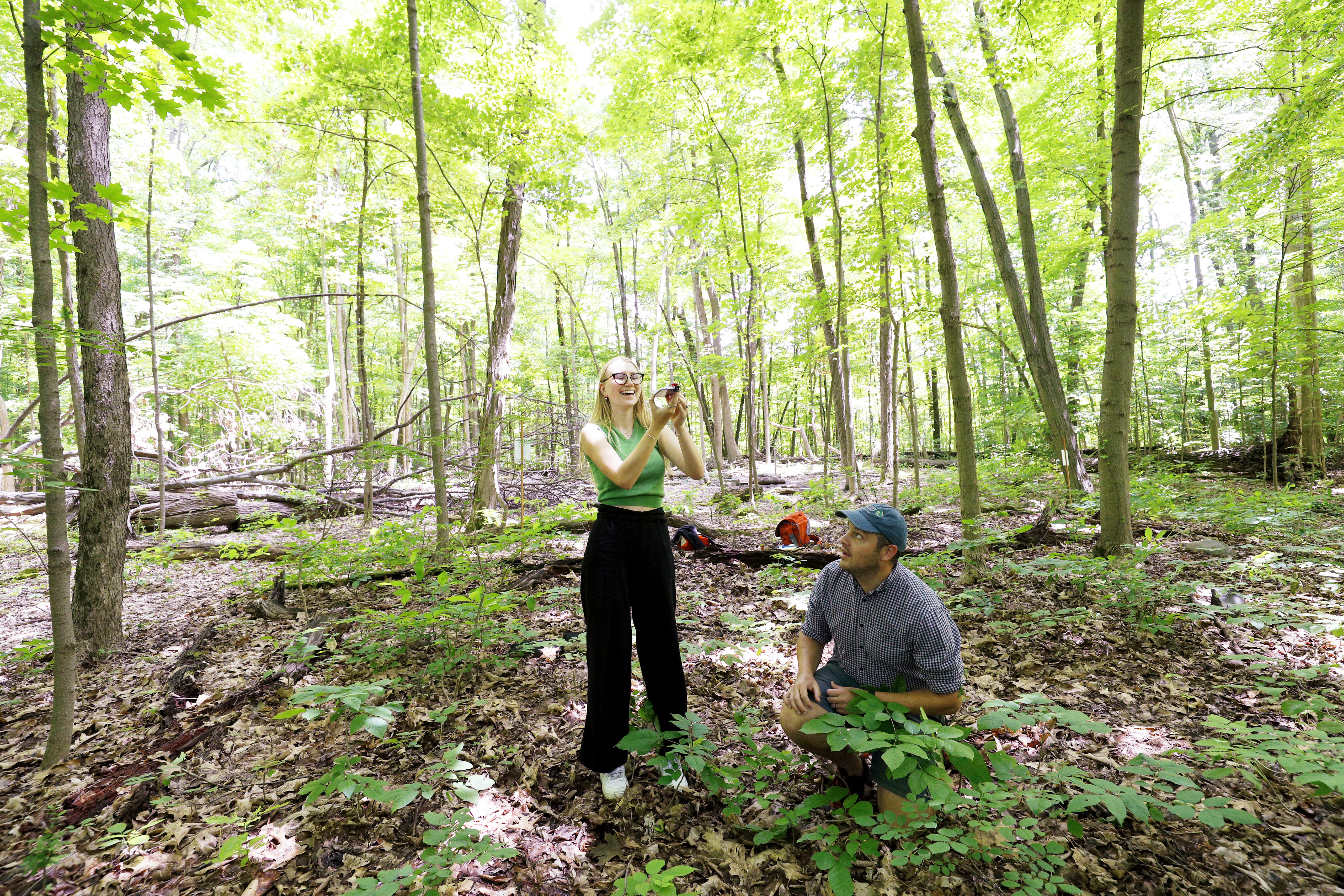 Christina Lindstrom '23 takes photos of the canopy in North Woods as part of a project with Charlie Bettigole, director of the GIS Center for Interdisciplinary Research at Skidmore. 