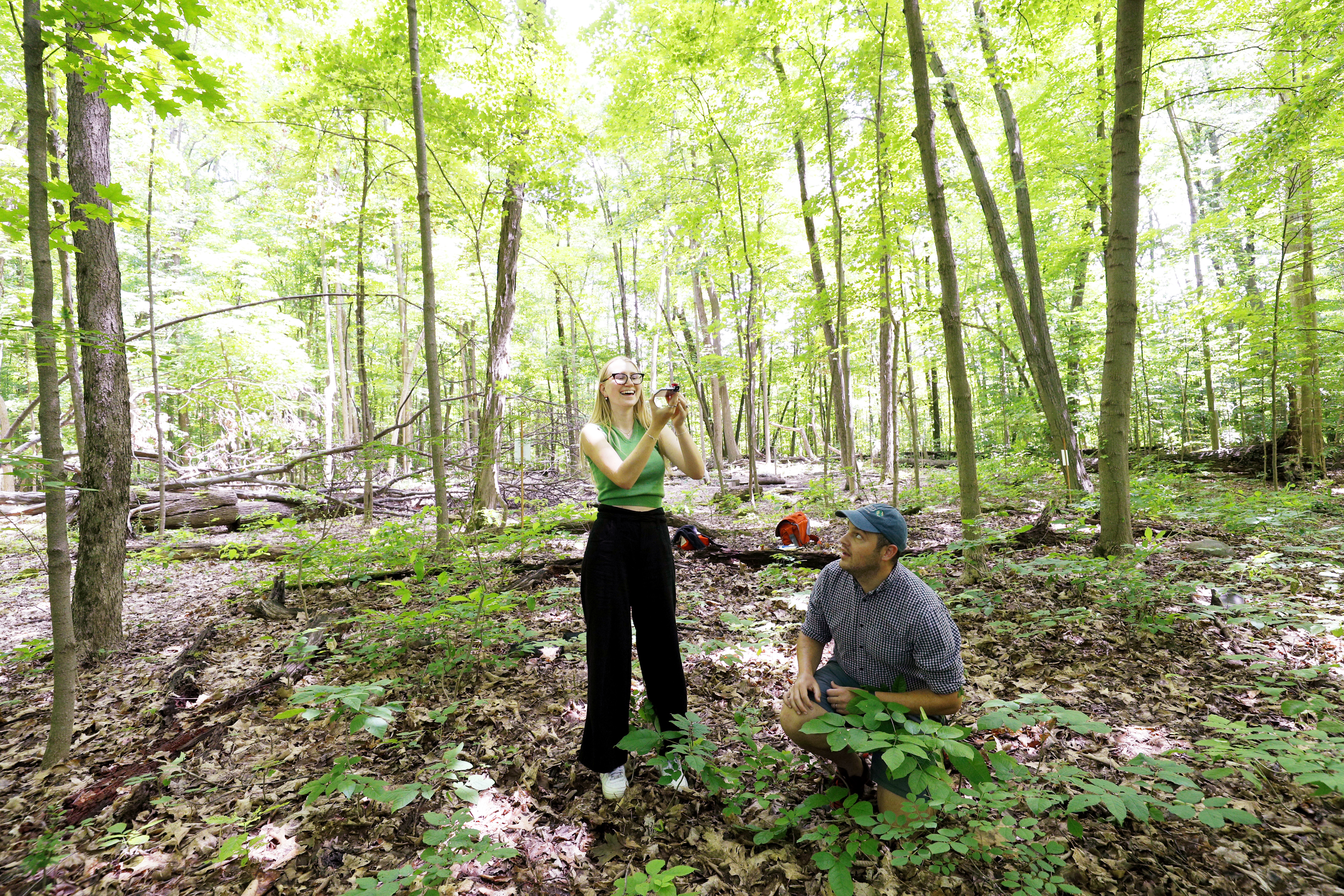 Christina Lindstrom '23 takes photos of the canopy in North Woods as part of a project with Charlie Bettigole, director of the GIS Center for Interdisciplinary Research at Skidmore.