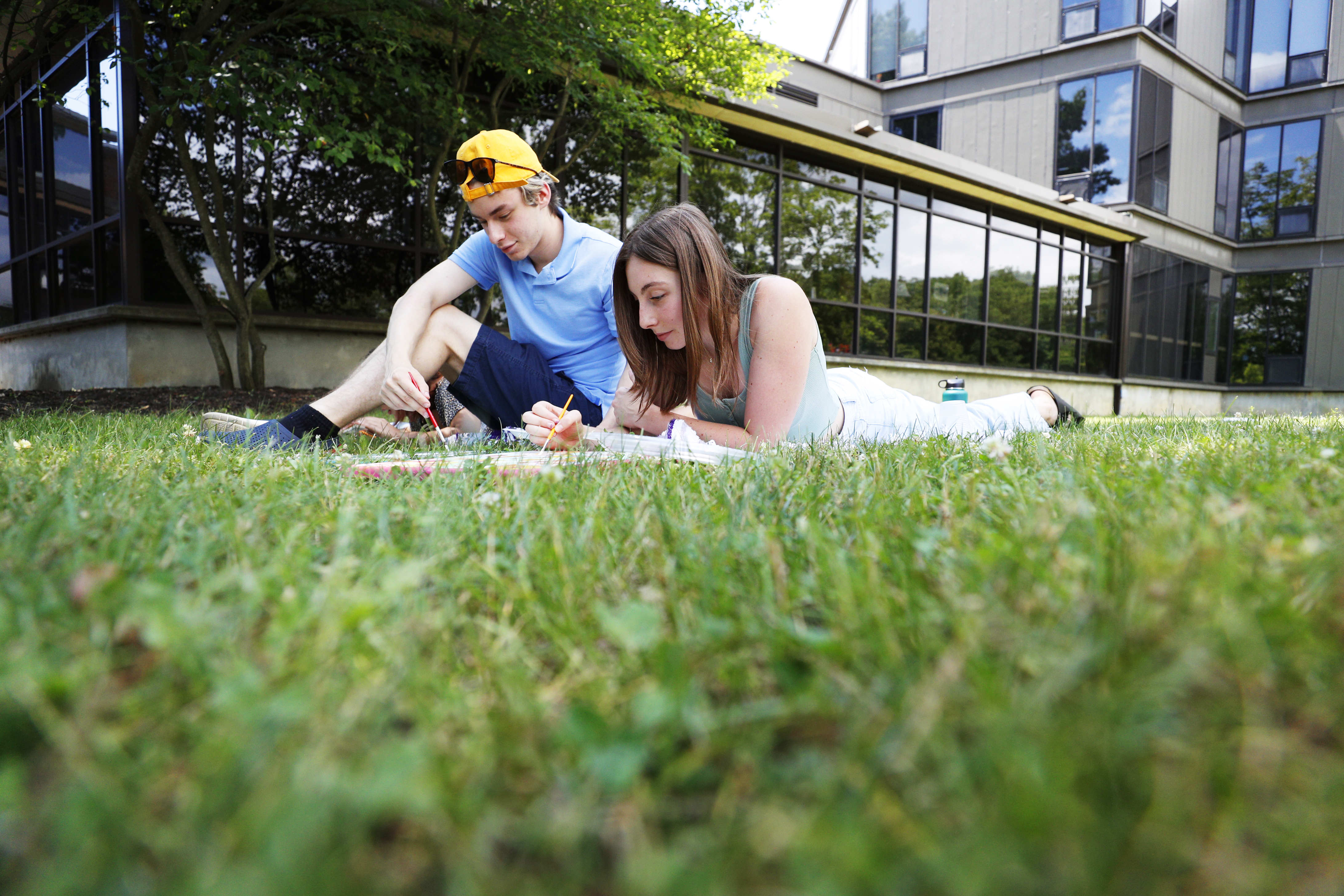 Ray East ’23 and Elizabeth Miller ’23 paint on the lawn in front of Palamountain Hall.  