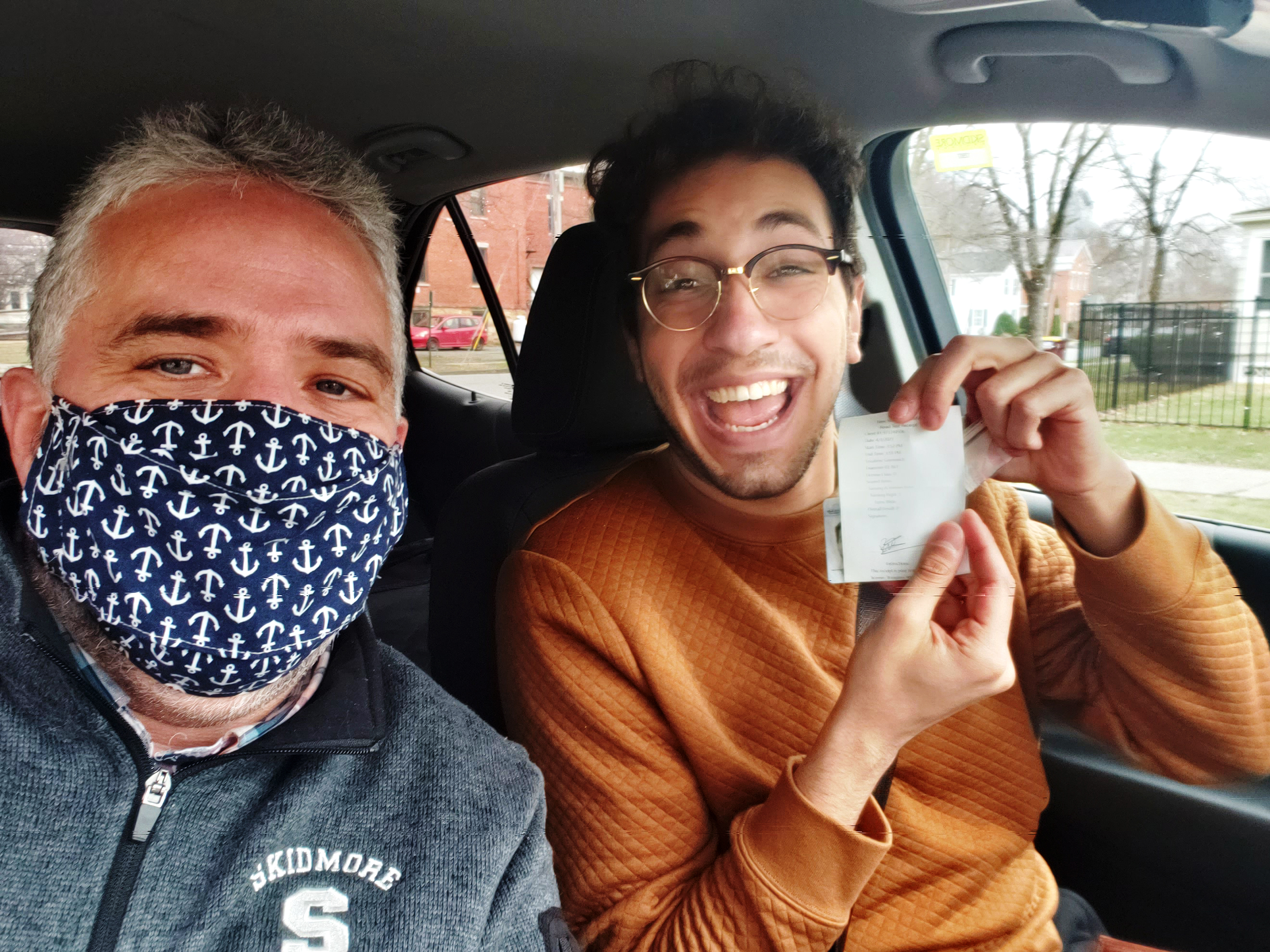 Patrick Tavares ‘21 of Brazil, right, reacts after getting his driver's license with John Winnek, supervisor of retail operations in Dining Services at Skidmore. 