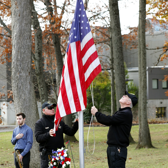 Campus+Safety+officers+raise+the+flag+at+a+Veterans+Day+ceremony.+