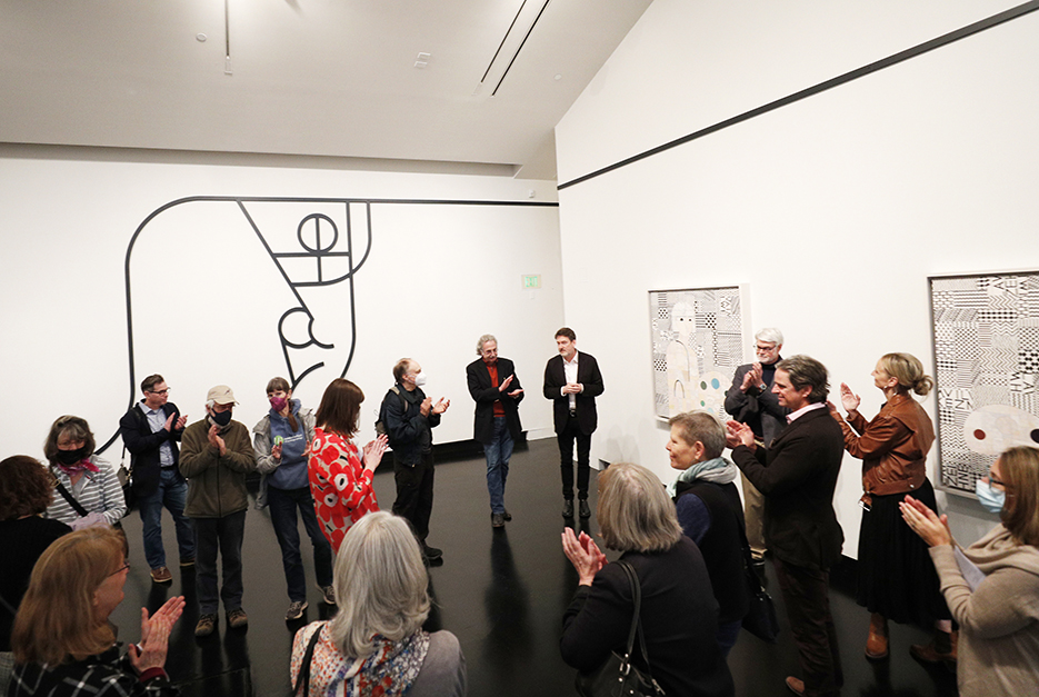 Participants in this year's Humanistic Inquiry Symposium offer applause during a tour of the exhibition "Opener 34: Ruby Sky Stiler — New Patterns" offered by Dayton Director of the Tang Teaching Museum and Art Gallery Ian Berry. (Photo: Sarah Condon-Meyers)