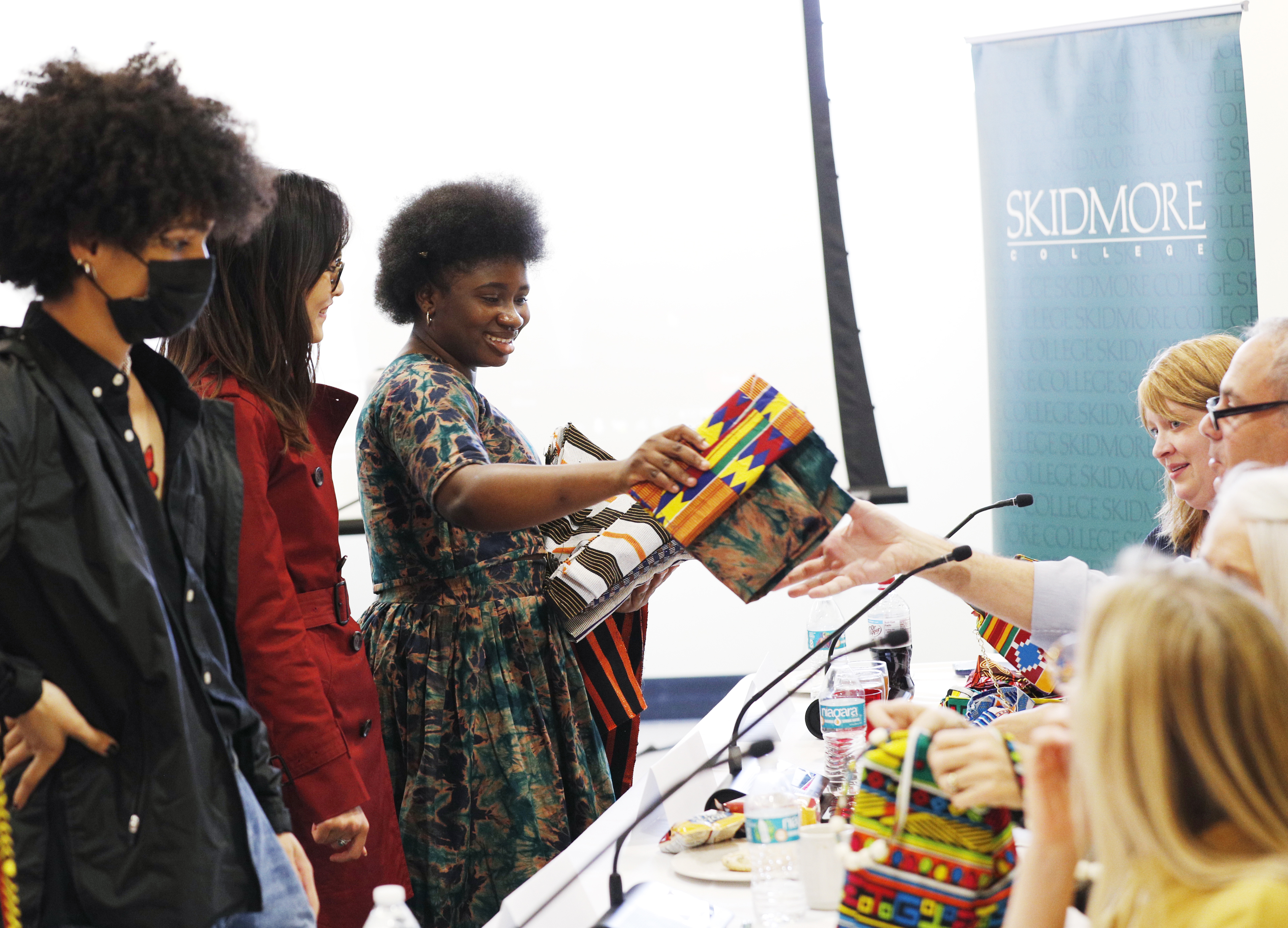 Freirich Competition finalist Malika Sawadogo '24 hands out designs from her business MESTH during competition finals.