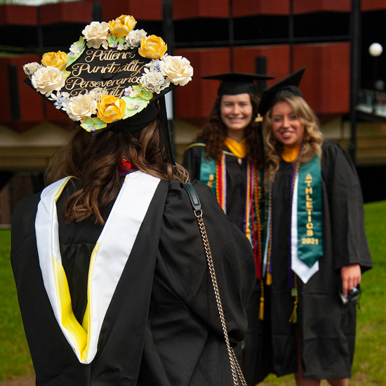 Three+female+college+graduates+in+undergraduate+regalia+