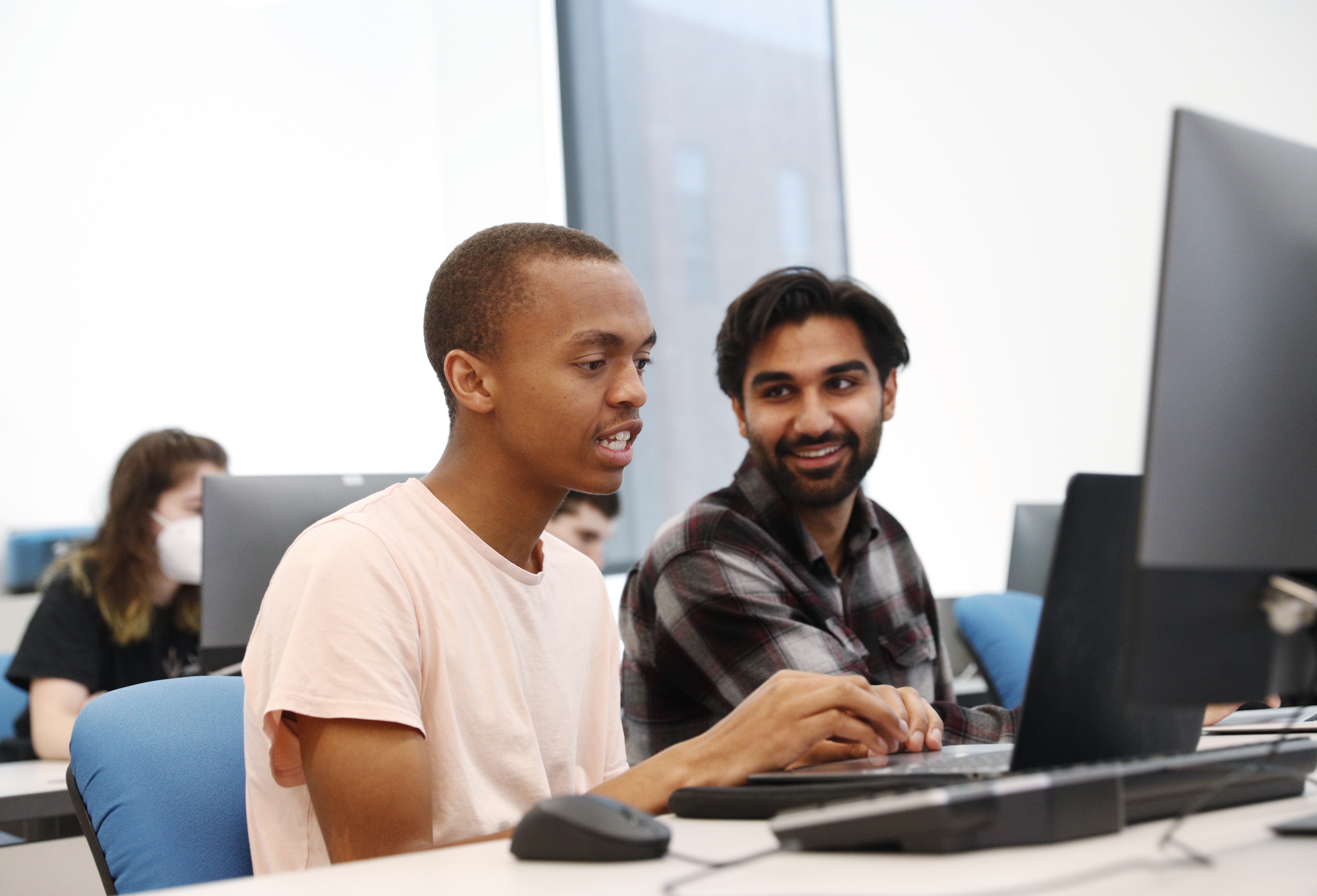 two students work together in a computer lab