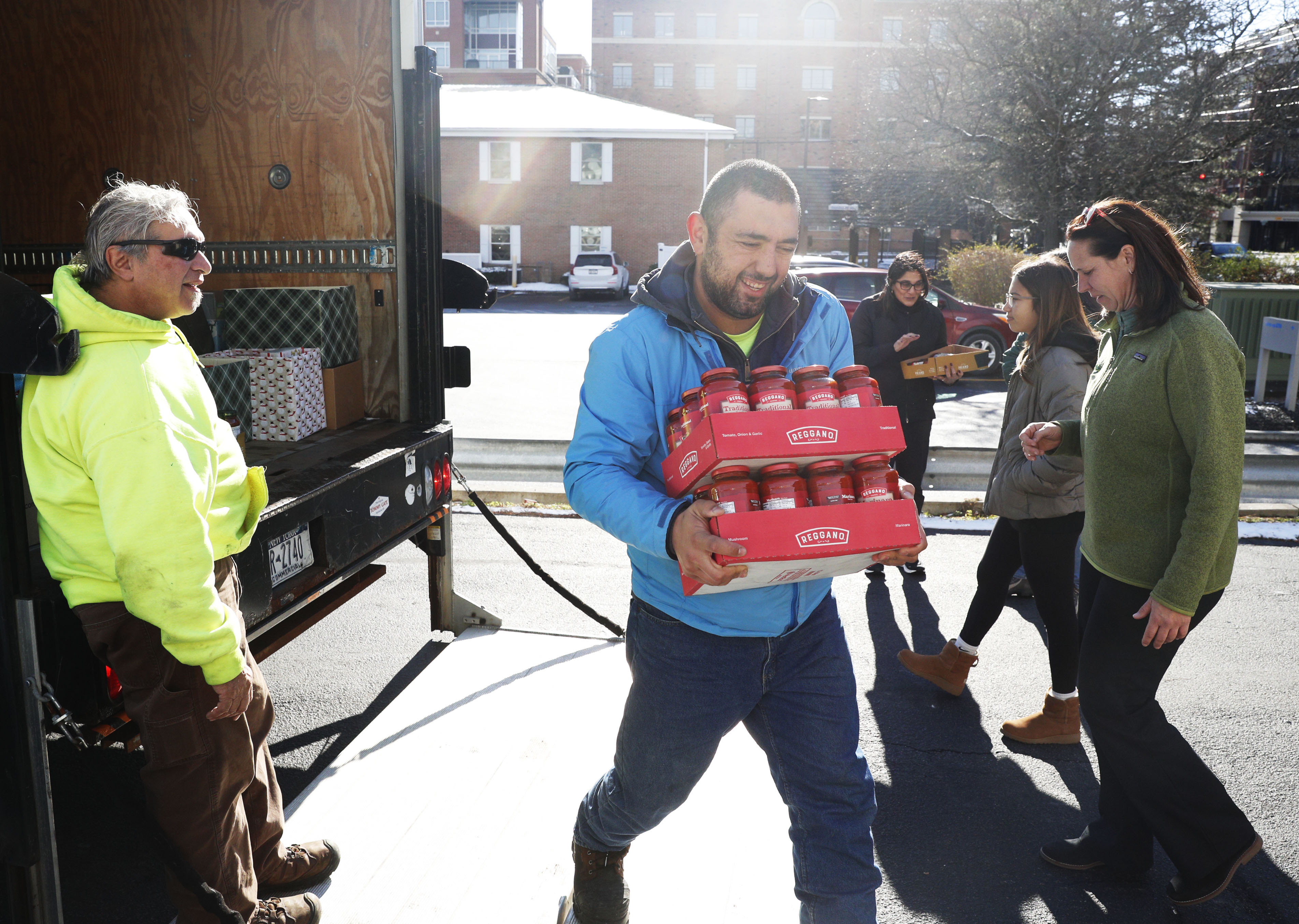 Skidmore employee Mustafa Güçlü carries tomato sauce donated for Skidmore Cares.  