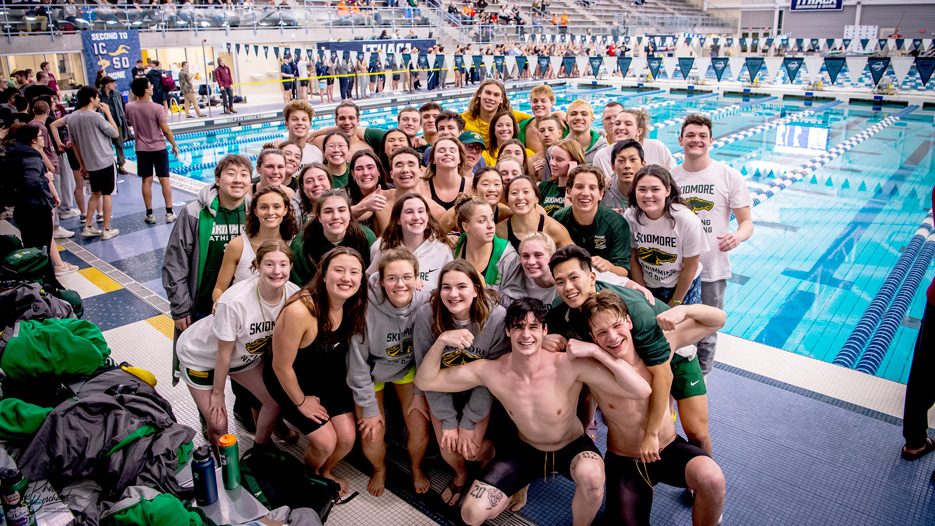 Group photo of the Skidmore swimming and diving team beside an indoor pool