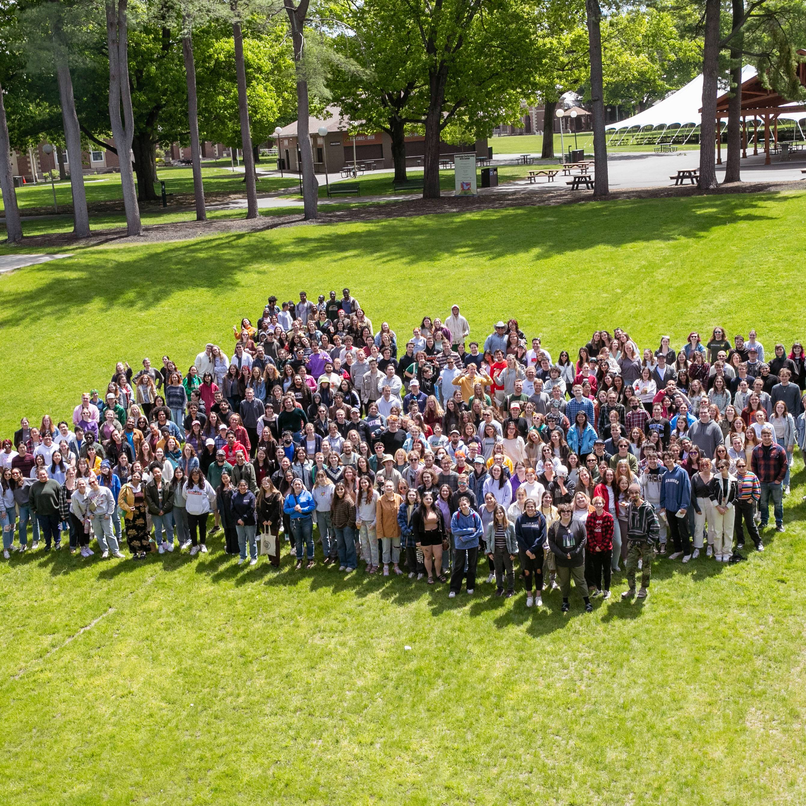 A+crowd+of+over+500+college+students+stand+in+a+grassy+field