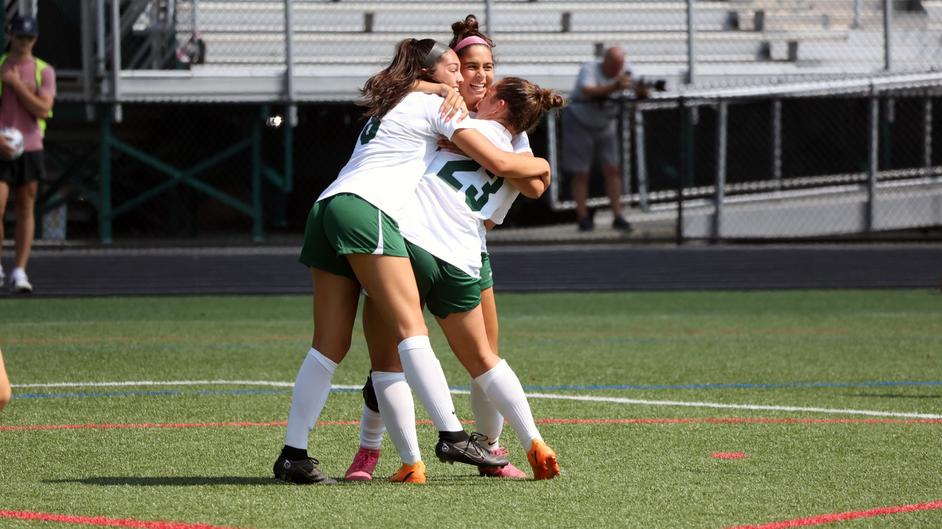 Members of the women's soccer team celebrate the game-winner against SUNY Brockport.