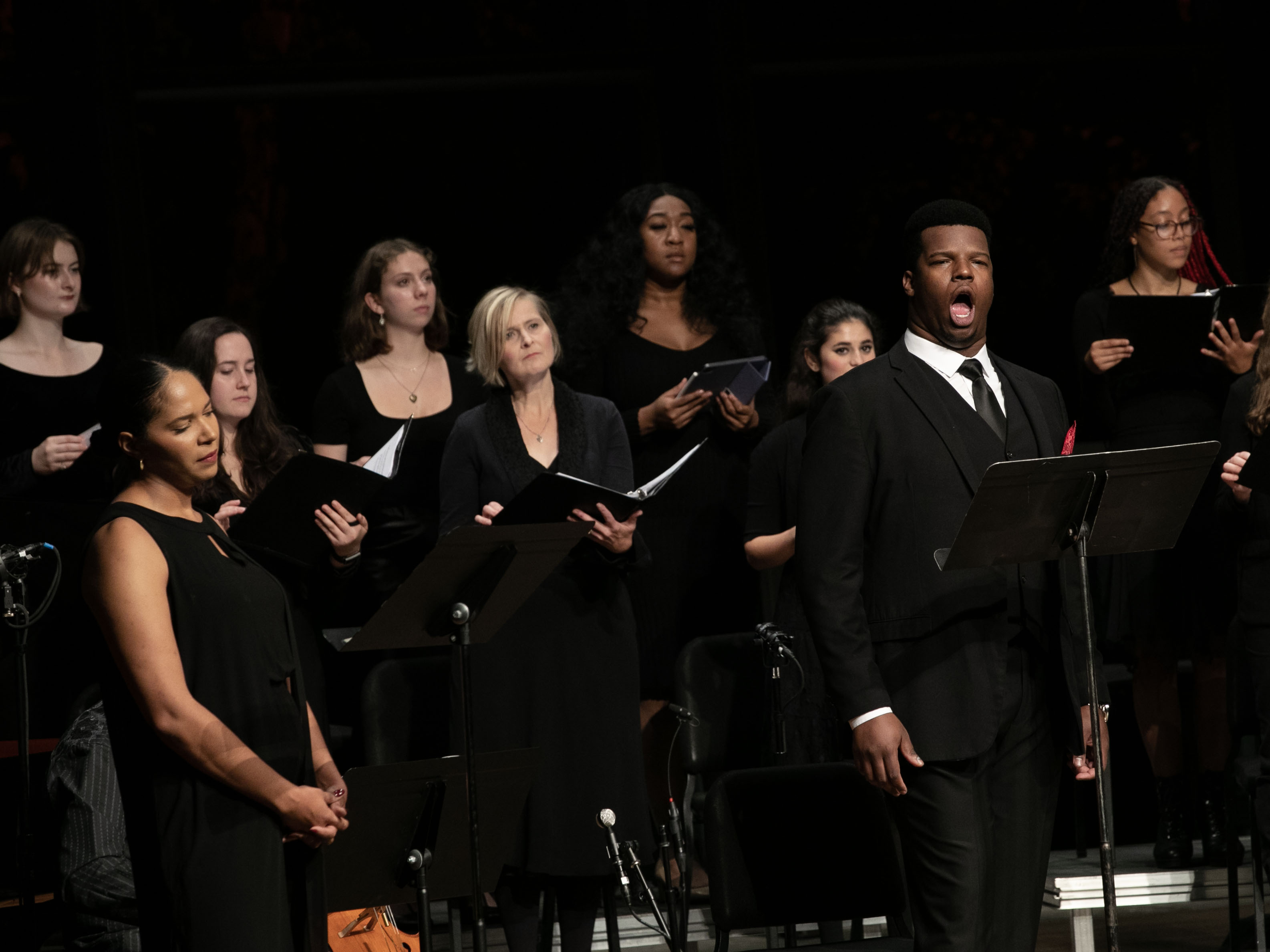 A choir dressed in black performs "The Unhealed Wound" passionately.