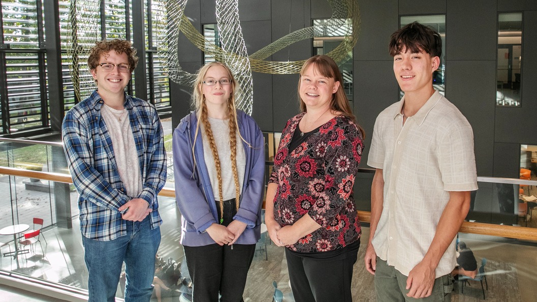 Jacob Lord '24 (far left), Lily Watson ’27 (middle left), Jude Remenar ’27 (far right), and Rebecca Johnson (middle left) stand on a balcony overlooking the main floor of Billie Tisch Center for Integrated Sciences.