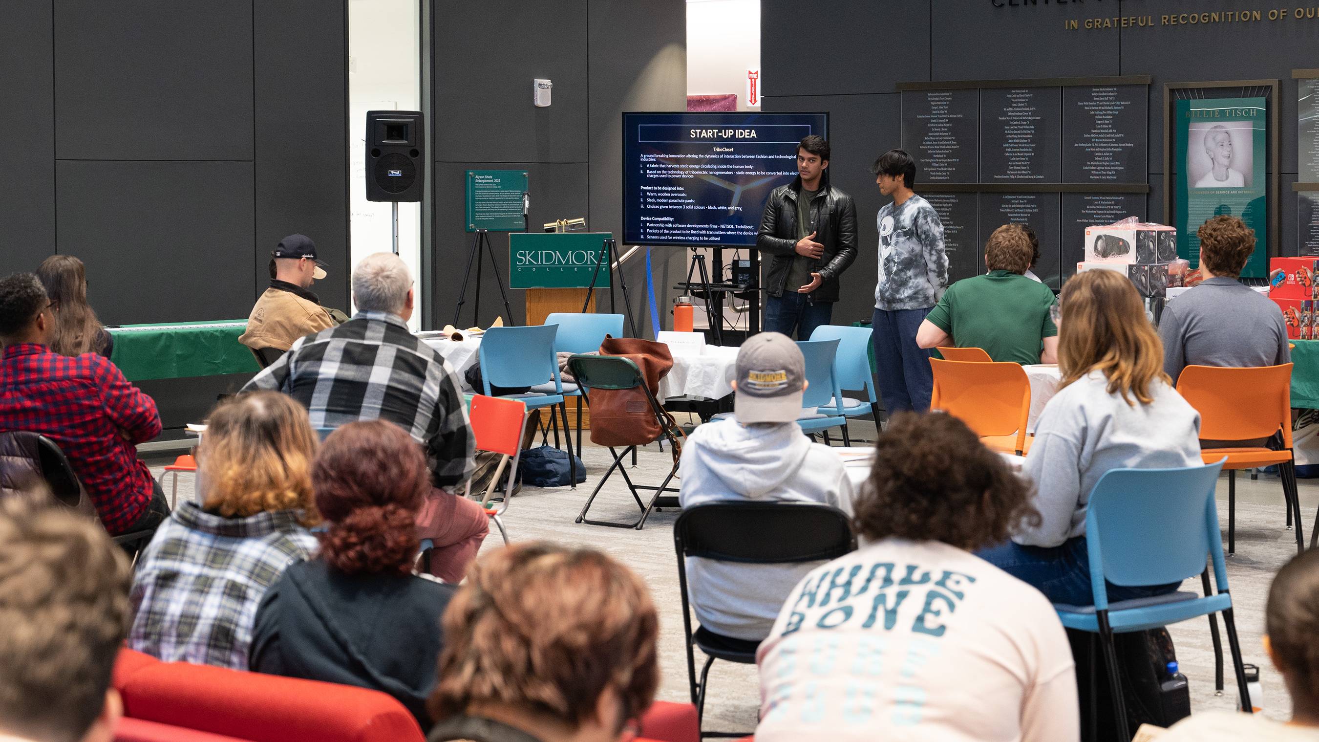 Muhammad Salim ’27 and Yash Manandhar ’27 present their idea, Tribocloset, in the Billie Tisch Center for Integrated Sciences. A crowd can be seen watching.