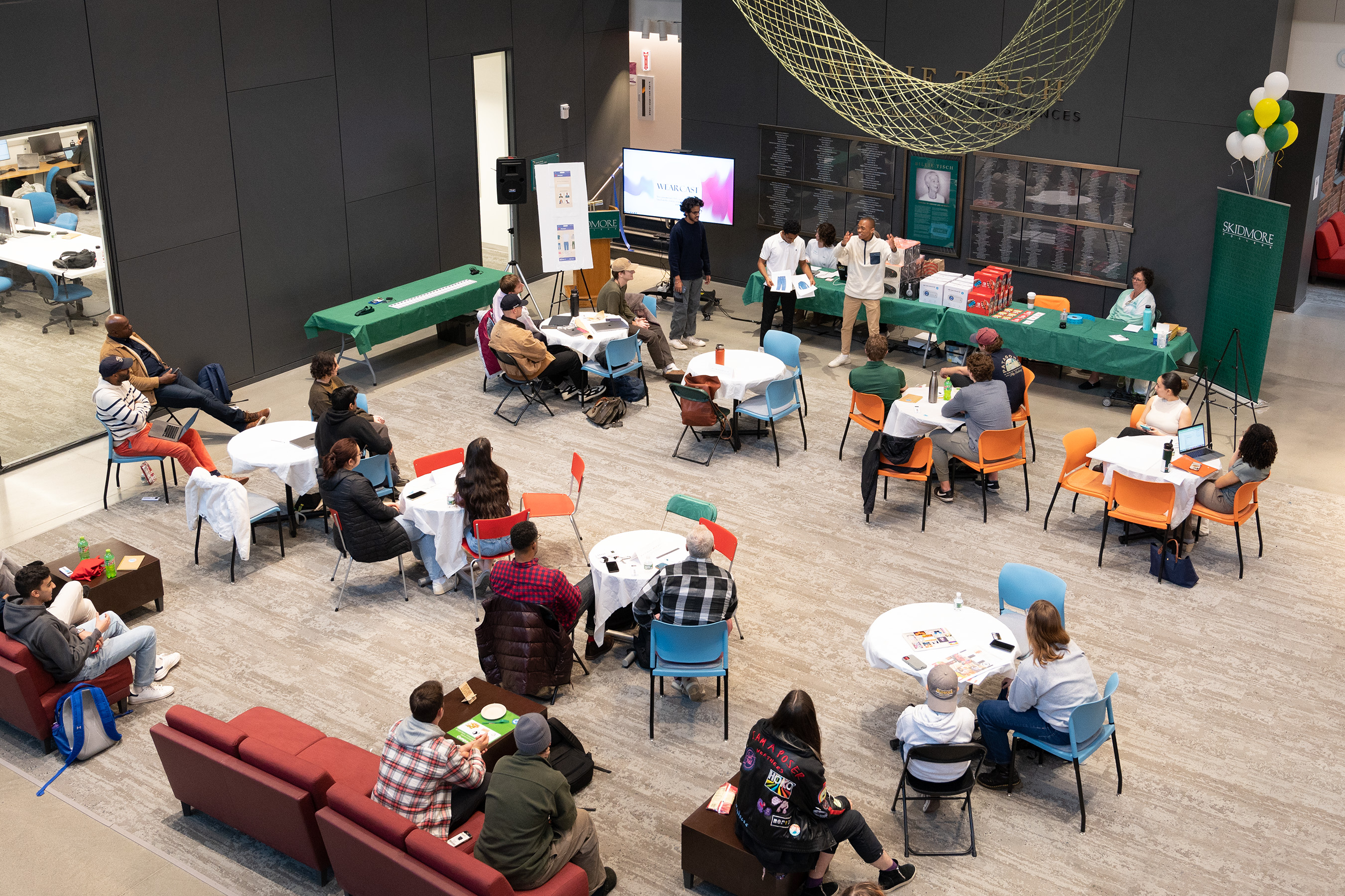 Arjun B K '25, Siyabonga Mabuza '25, Kartik Vaish '25 can be seen presenting their idea, Wearcast, in front of a crowd in Billie Tisch Center for Integrated Sciences.