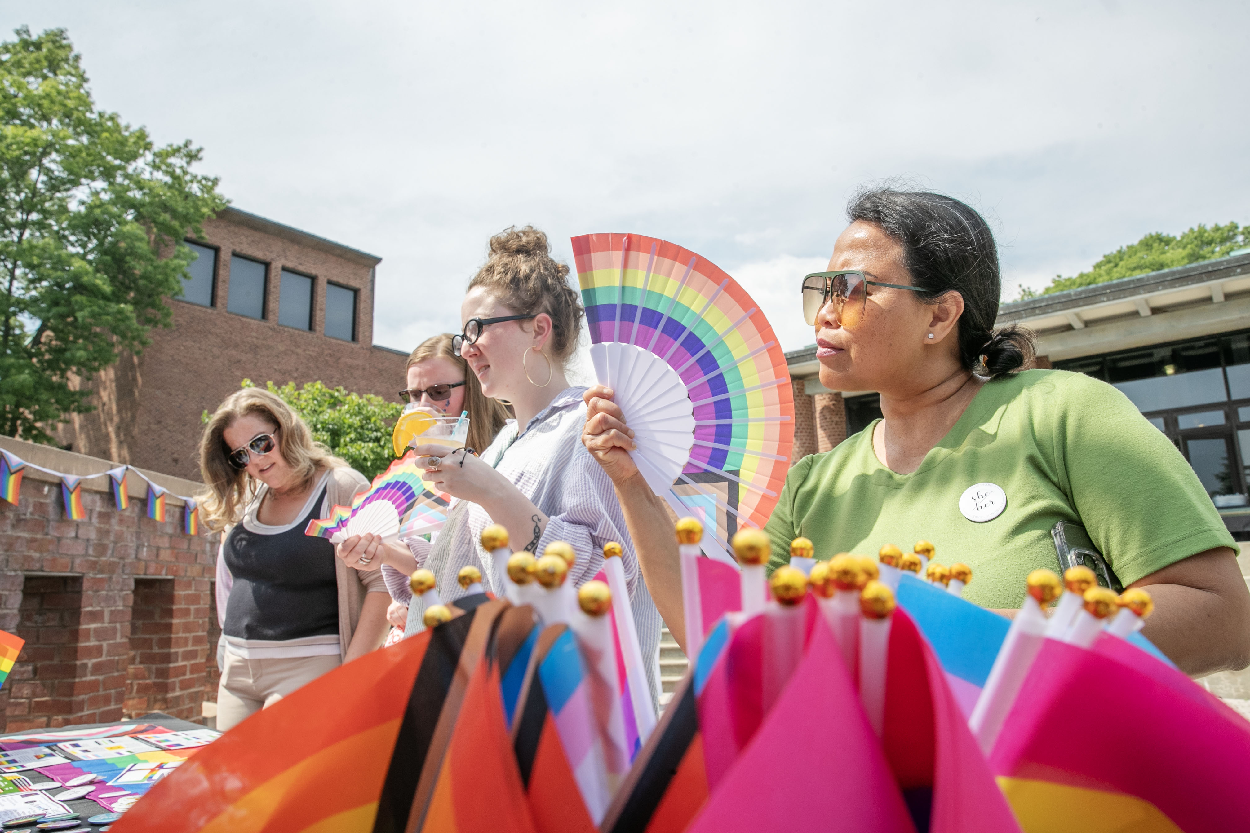 Attendees using Pride-themed fans to keep cool