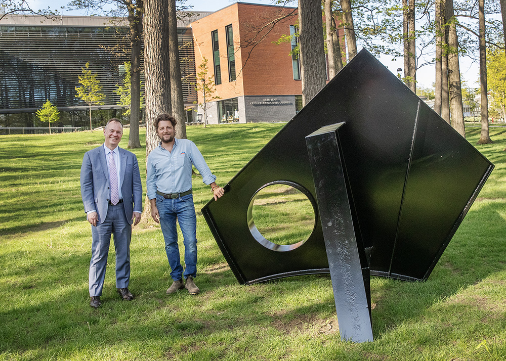 Fitzhugh Karol '04 and President Marc C. Conner stand beside the new sculpture on Skidmore's campus.