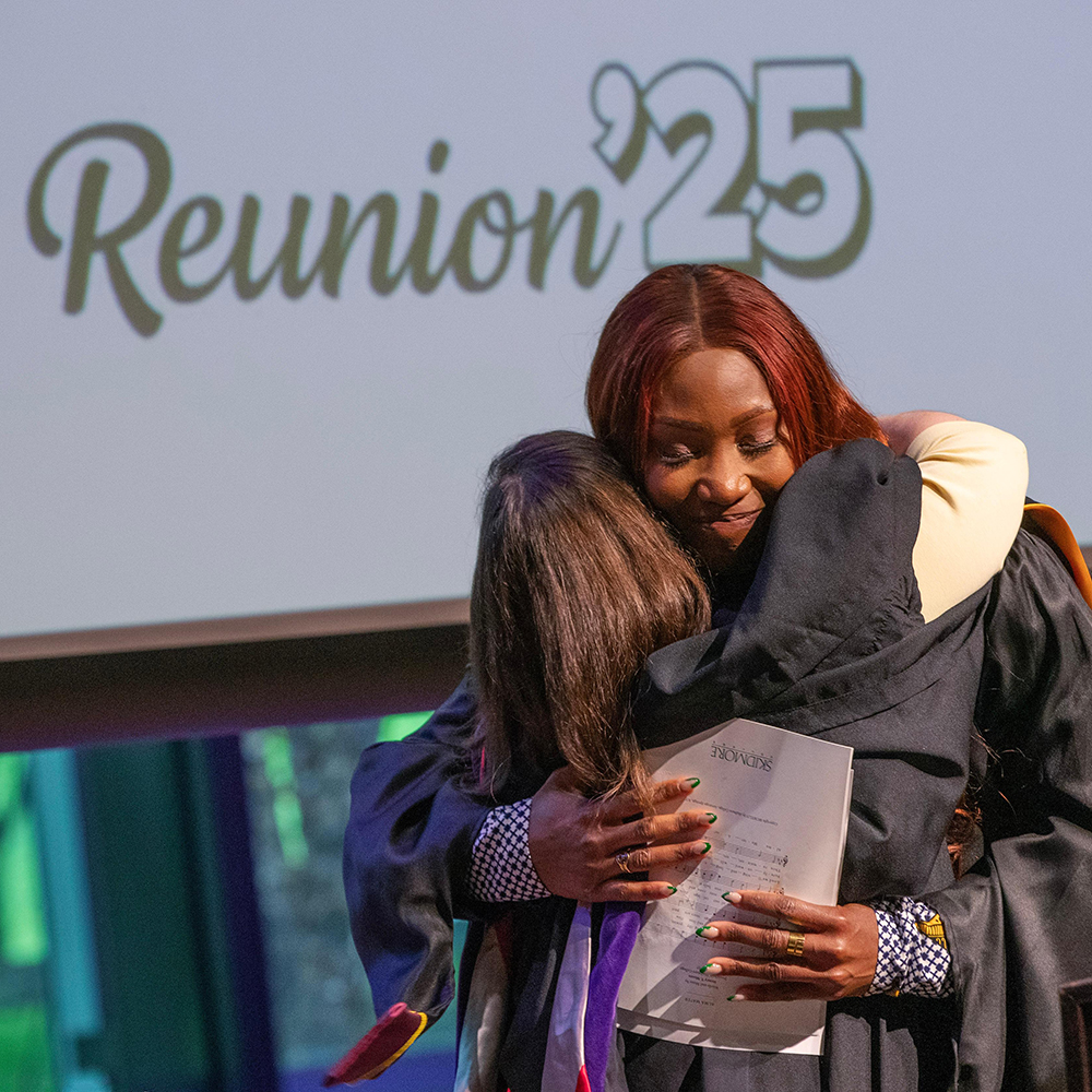 An+alumna+award+recipient+hugging+another+alum+