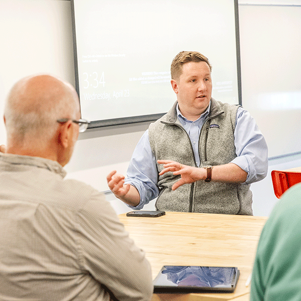 Matt+Walsh+%2713+sits+at+a+table+in+discussion+with+faculty+members