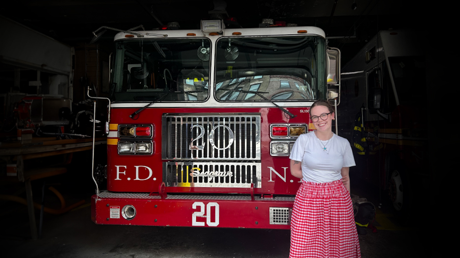 Skidmore alumna Lily Ross stands in front of a firetruck and smiles for a photo.