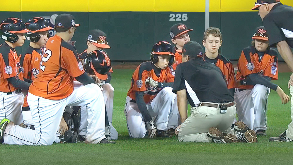 Coach Dave Belisle speaking to Trey Bourque '25 and Cumberland American teammates following their hard-fought defeat at the 2014 Little League Baseball World Series.