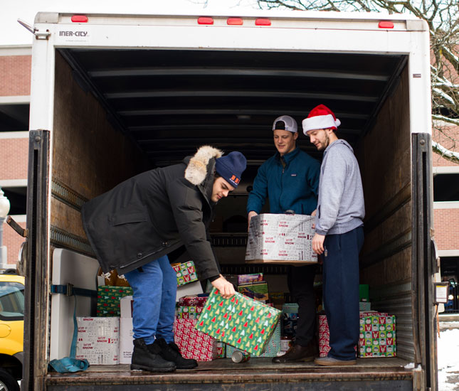 Skidmore student-athletes load a truck with holiday donations for the local community in 2019.