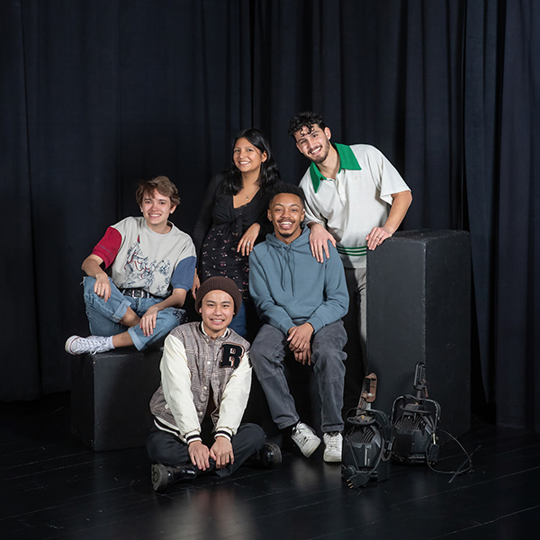 The+first+five+Miranda+Fellows+at+Skidmore+pose+in+a+theater+studio+with+a+black+curtain+as+a+backdrop